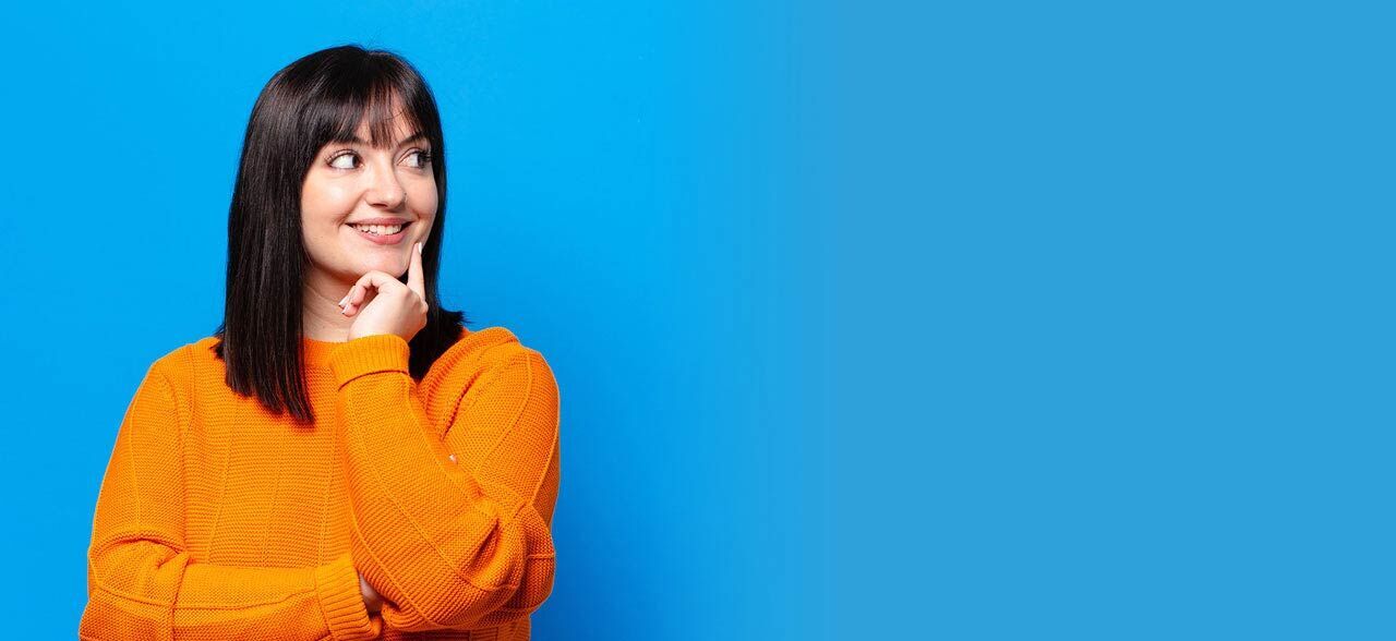 eine Frau in einem orangefarbenen Pullover lächelt